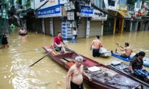 Ngồi thuyền phát mì gói cứu trợ nơi nước ngập đến đầu gối